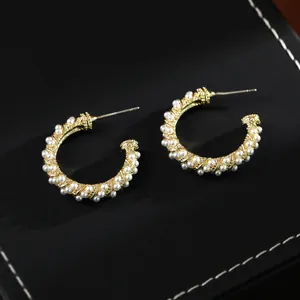 Elegant C-shaped gold-plated pearl hoop earrings featuring a vintage woven texture design