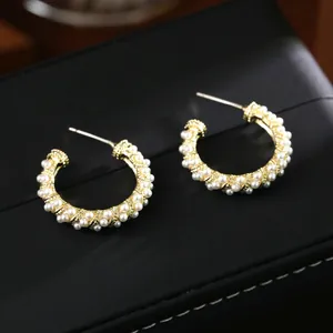 Elegant C-shaped gold pearl hoop earrings for women featuring white bead embellishments