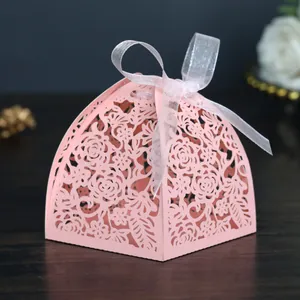 Dettaglio della scatola regalo rosa tagliata al laser con motivi a rose e nastro bianco