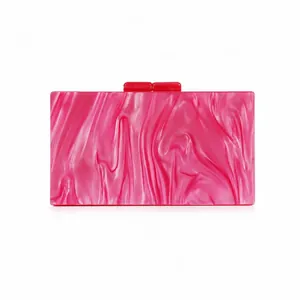 Detail of pink marble textured acrylic evening clutch bag with red rectangular clasps