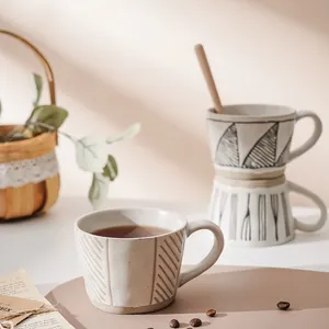 Hand-painted Japanese stoneware coffee mug with geometric patterns and wooden spoon