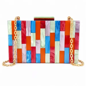 Macro detail of acrylic patchwork evening bag with colorful marble patterns and gold chain