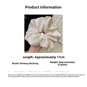 Detailed size view of an oversized cream satin scrunchie measuring 17cm in length