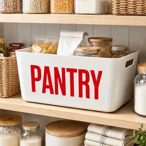 Close-up of white pantry storage basket with large red text on a wooden shelf