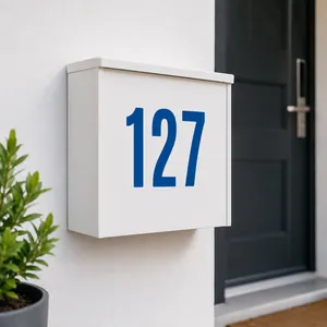 Detail of matte white mailbox with blue number 127 sticker on a textured wall