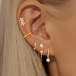 Elegant 24K gold plated flower earrings set with zircon stones on model's ear