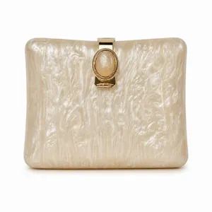 Close-up of pearlized marble acrylic clutch bag with elegant golden metal clasp