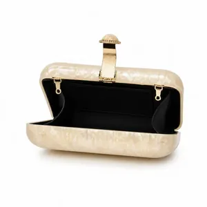 Detail view of pearlescent acrylic box clutch with golden frame and marble texture