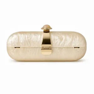 Detail of pearlescent acrylic capsule clutch with marble bead and golden metal hardware