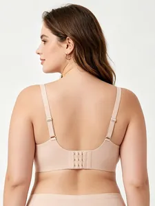 Detail view of seamless beige bra showing wide adjustable straps and triple hook closure