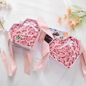Pink heart-shaped gift box set with roses and elegant silk ribbon on marble background