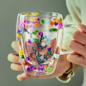 Double-walled borosilicate glass mug filled with colorful dried flowers and a round handle