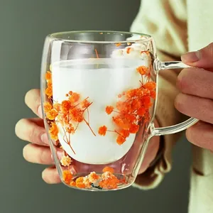 Double-walled glass cup with dried orange flowers and handle, perfect for milk and tea