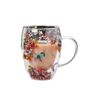 Insulated double wall glass mug with colorful dried flowers inside and clear handle