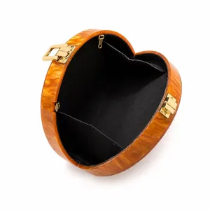 Detail of heart-shaped acrylic evening clutch showing black fabric interior and card pocket