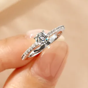 Close-up of 14k gold plated moissanite ring with four-prong setting on a finger