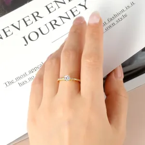 Close-up of 14k gold-plated moissanite ring with pave-set side stones on a finger