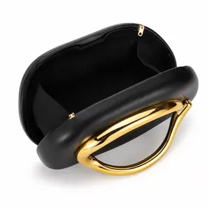 Chic black shell shaped acrylic handbag with signature large gold curved metal handle