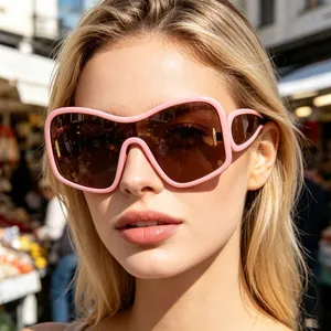 Close-up of stylish oversized pink sunglasses with dark brown lenses on female model
