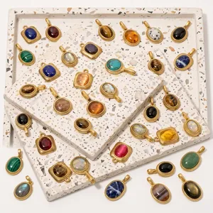 Detail of vintage gold-plated pendants with colorful oval natural stones on stone display