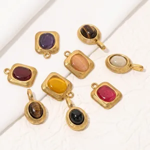 Macro view of assorted oval natural stone pendants with gold stainless steel frames