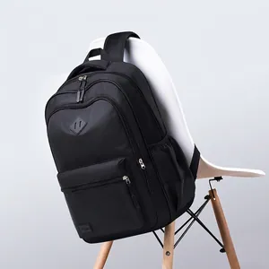 Minimalist black large capacity backpack with diamond patch on white chair