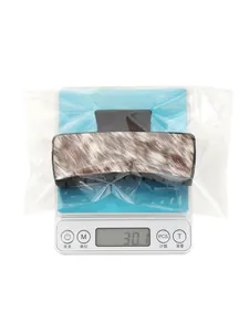 Close-up of leopard print hair claw clip on electronic scale weighing 30.1 grams