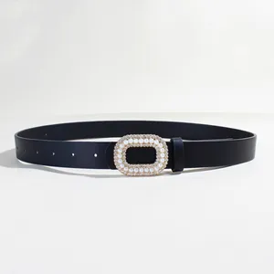 Dettaglio della fibbia nera per cintura con perle incastonate e strass brillanti chic