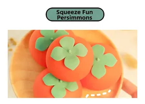 Detailed view of an orange persimmon squeeze toy with green leaf on a wooden tray
