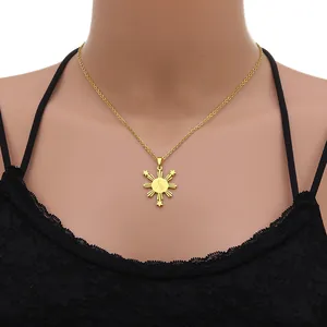 Vue détaillée d'un pendentif soleil des Philippines doré sur un haut en dentelle