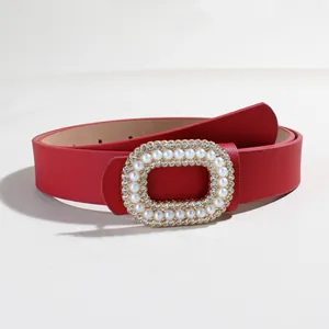 Dettaglio della cintura in ecopelle rossa con fibbia ovale in perle e strass lucidi