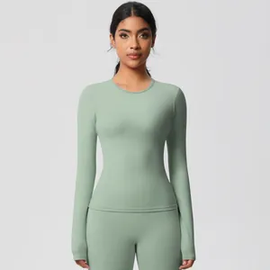 Detail of mint green yoga top showing thumbhole cuffs and stretchy brushed fabric