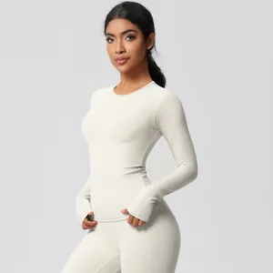 Detail view of light beige slim fit yoga top with thumbholes and soft matte fabric