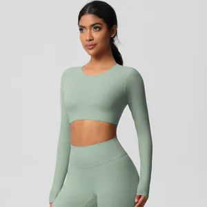 Detail of sage green seamless yoga set featuring long sleeve crop top and high waist leggings