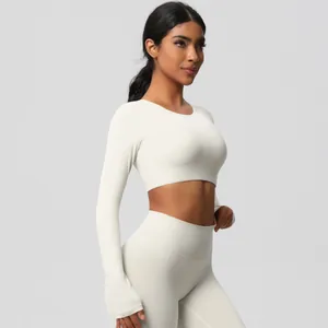 Detail of high-waist yoga pants and cropped top with thumbhole sleeves in creamy white