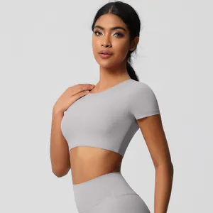 Detail of light gray high-waisted seamless leggings and cropped short sleeve yoga top