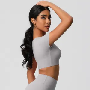 Side view of woman in light grey seamless yoga set featuring slim fit crop top and high waist leggings