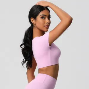 Detail view of pink slim fit crop top yoga shirt with moisture wicking matte fabric