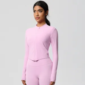 Detail of light pink yoga set featuring a stand collar zip-up top and high-waist leggings