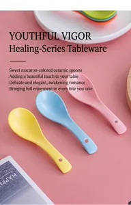 Close-up of pastel ceramic spoons in pink, blue and yellow with handle hanging holes
