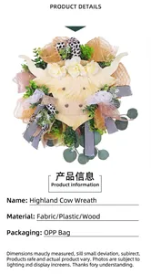 Detail of Highland Cow wreath with faux white roses, eucalyptus leaves, and burlap ribbons