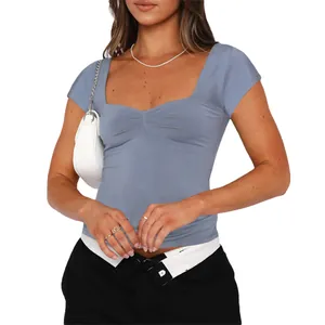 Détail d'un t-shirt bleu-gris ajusté avec fronces à la poitrine et col carré élégant