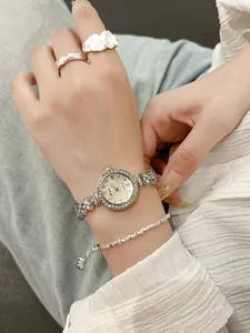Detailansicht einer kleinen silbernen Meerjungfrau-Uhr mit Strass-Lünette und Kette