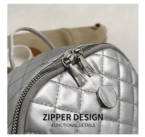 Close-up of silver quilted backpack featuring a smooth dual zipper and metallic texture