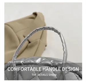 Detail of silver quilted handbag handle with fine stitching and satin finish texture