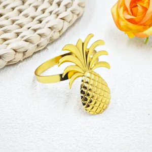 Elegant gold pineapple napkin ring with textured finish on a white surface with roses