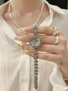 Makro-Detail der silbernen Meerjungfrau-Uhr mit Strass-Lünette und floralem Armband