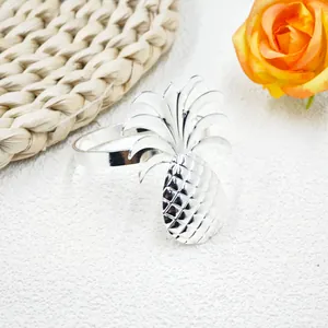 Elegant silver pineapple napkin ring with polished metal finish on a tropical table setting