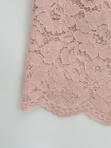 Close-up of elegant pink floral lace fabric with a detailed scallop edge hemline