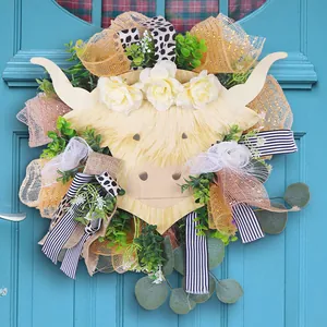 Highland cow floral wreath with white roses and plaid ribbons on a light blue door
